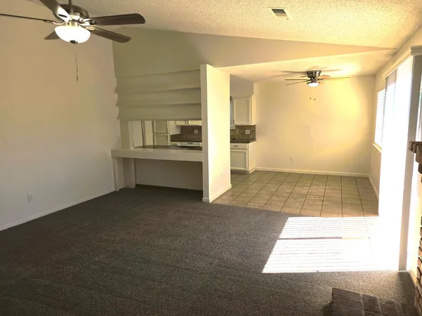 a view of a hallway with a dining table & chandelier