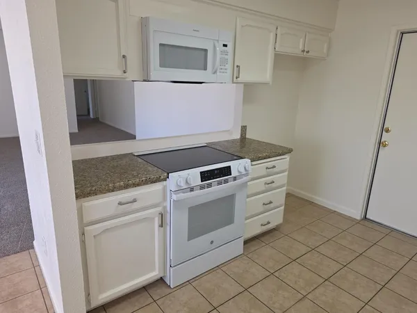 a kitchen with white cabinets and white appliances
