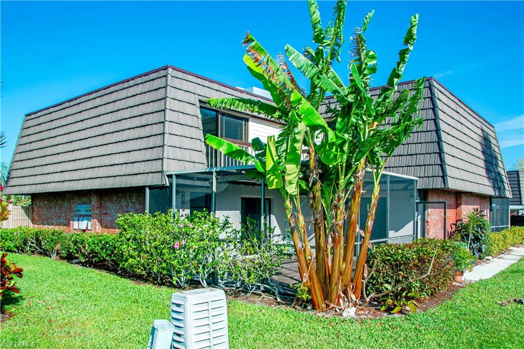 148 Lake Point Lane Naples, FL 34112 - Photo 5 of 17 a front view of a house with garden
