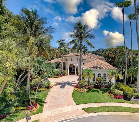 a front view of a house with a yard and potted plants