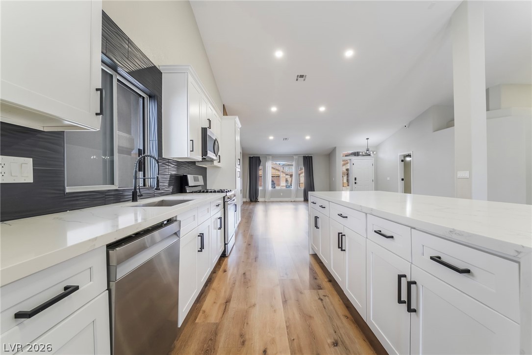 9171 West Viking Road Las Vegas, NV 89147 - Photo 15 of 43 A well-appointed kitchen showcasing contemporary design and seamless flow into an open living space.