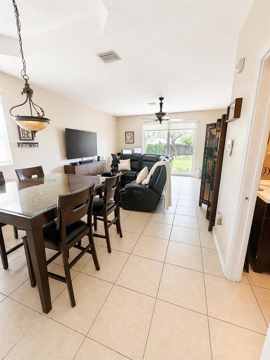 993 Northeast 3rd Avenue Homestead, FL 33030 - Photo 3 of 16 a living room with furniture a flat screen tv and a window