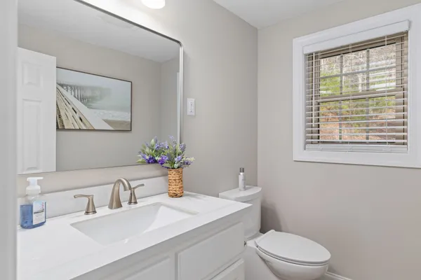 a bathroom with a sink a toilet and a window