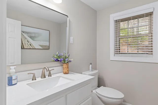 a bathroom with a sink a toilet and a window