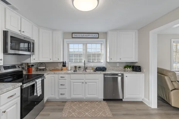 a kitchen with stainless steel appliances granite countertop a stove a sink dishwasher and a refrigerator