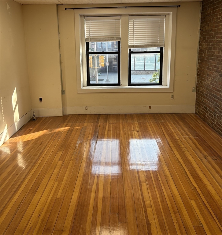 2020 Massachusetts Avenue, Unit 1 Cambridge, MA 02140 - Photo 2 of 11 a view of an empty room with wooden floor and a window