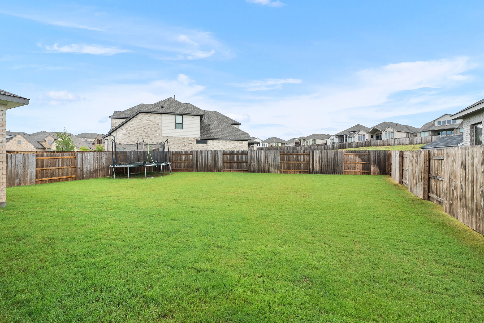 515 Watershield Cove Georgetown, TX 78633 - Photo 33 of 40 A spacious backyard enclosed by a tall wooden fence provides privacy and room for outdoor activities.