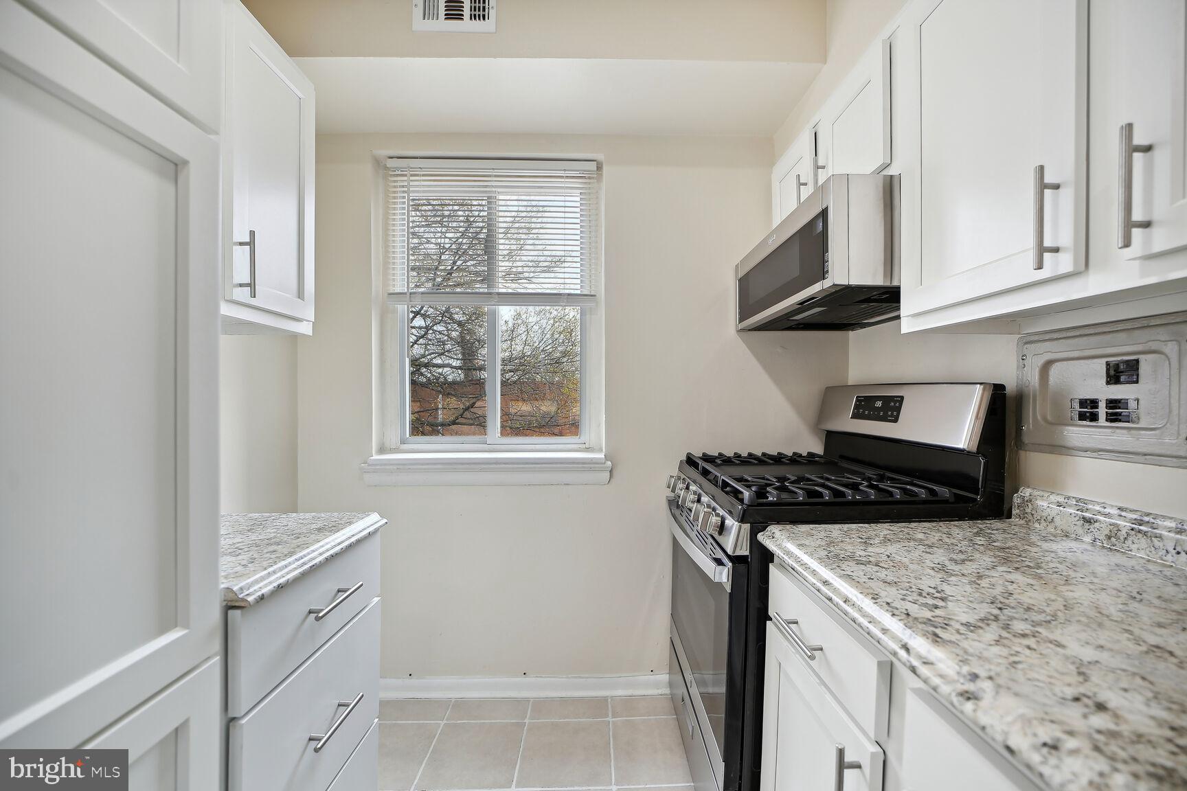 a kitchen with cabinets appliances and a window