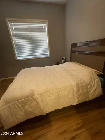 a bedroom with a bed and wooden floor