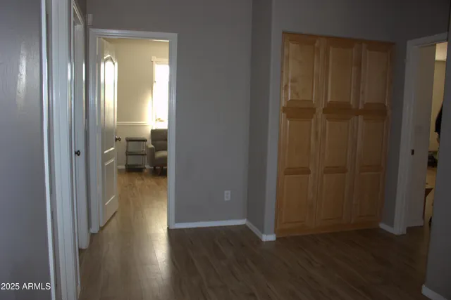 a view of a hallway with wooden floor and a bedroom