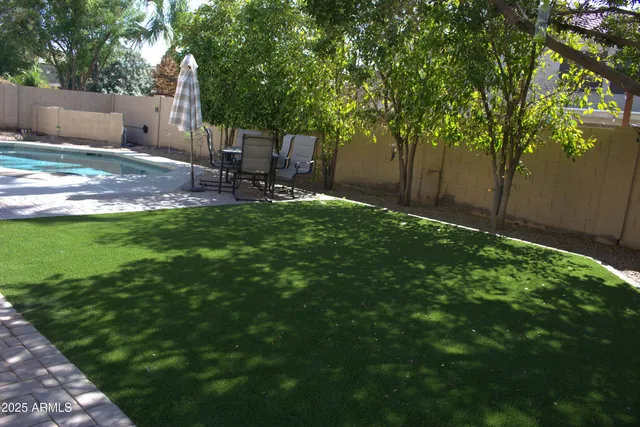 a backyard of a house with table and chairs