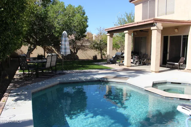 a backyard of a house with barbeque oven table and chairs