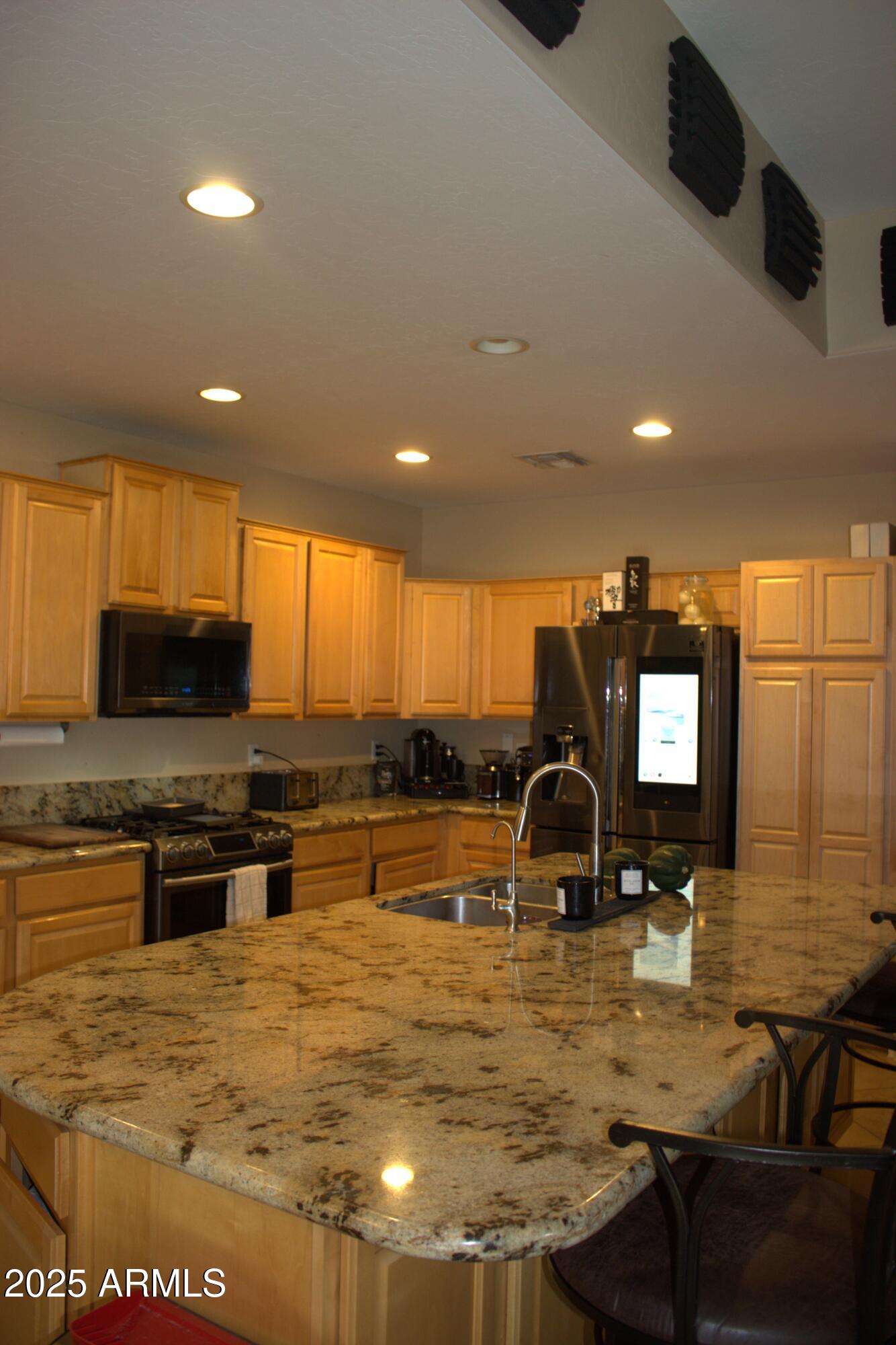 1433 West Longhorn Drive Chandler, AZ 85286 - Photo 10 of 27 a kitchen with stainless steel appliances granite countertop a sink stove and granite counter top