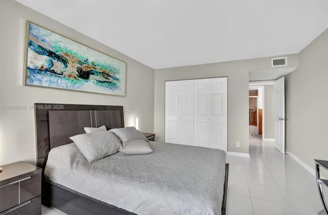 a bedroom with a bed and a painting on the wall