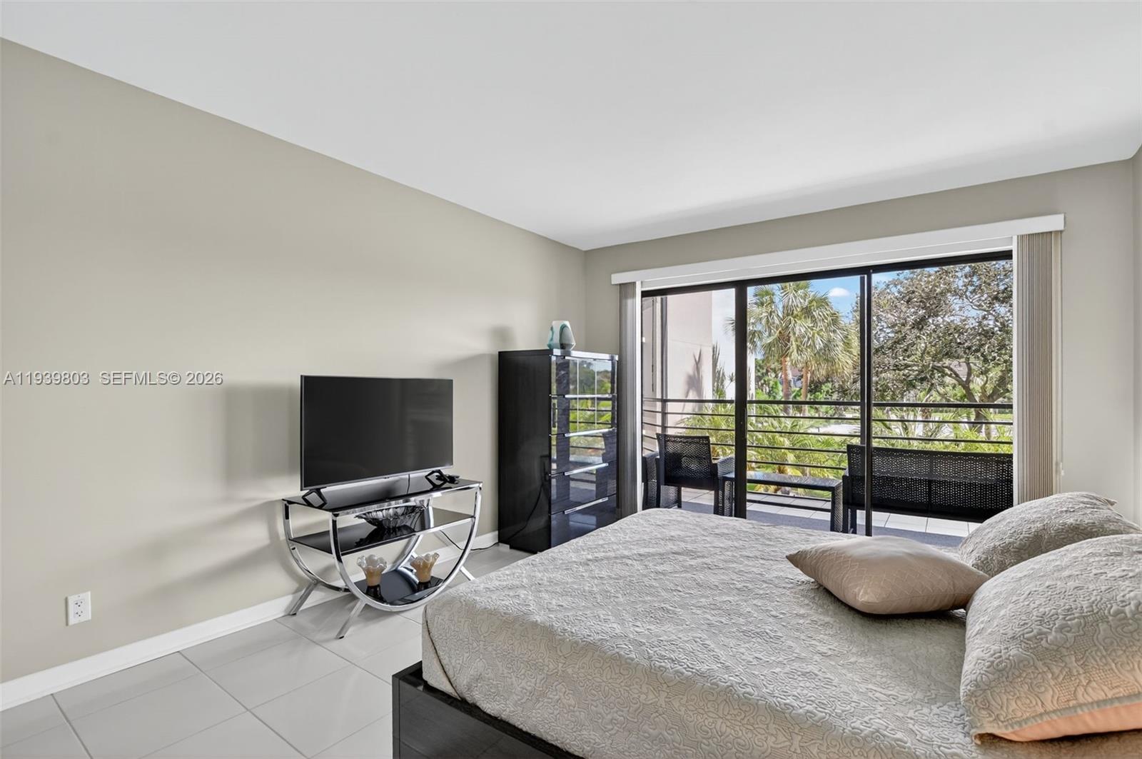 5901 Camino Del Sol, Unit 207 Boca Raton, FL 33433 - Photo 17 of 53 a bedroom with a bed and a large window