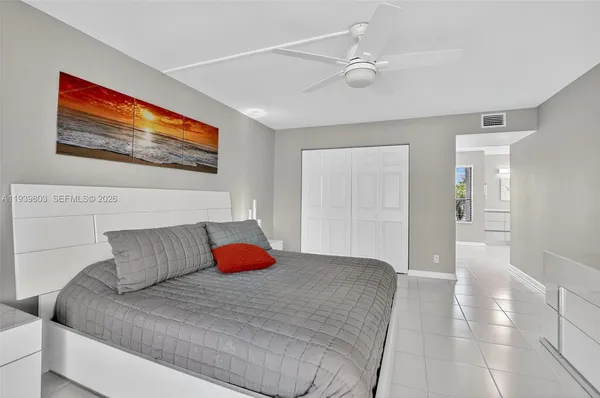 a bedroom with a large bed and a painting on the wall