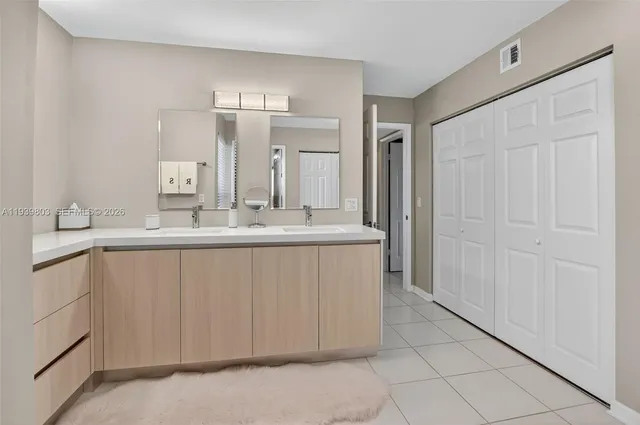a bathroom with a double vanity sink and a mirror