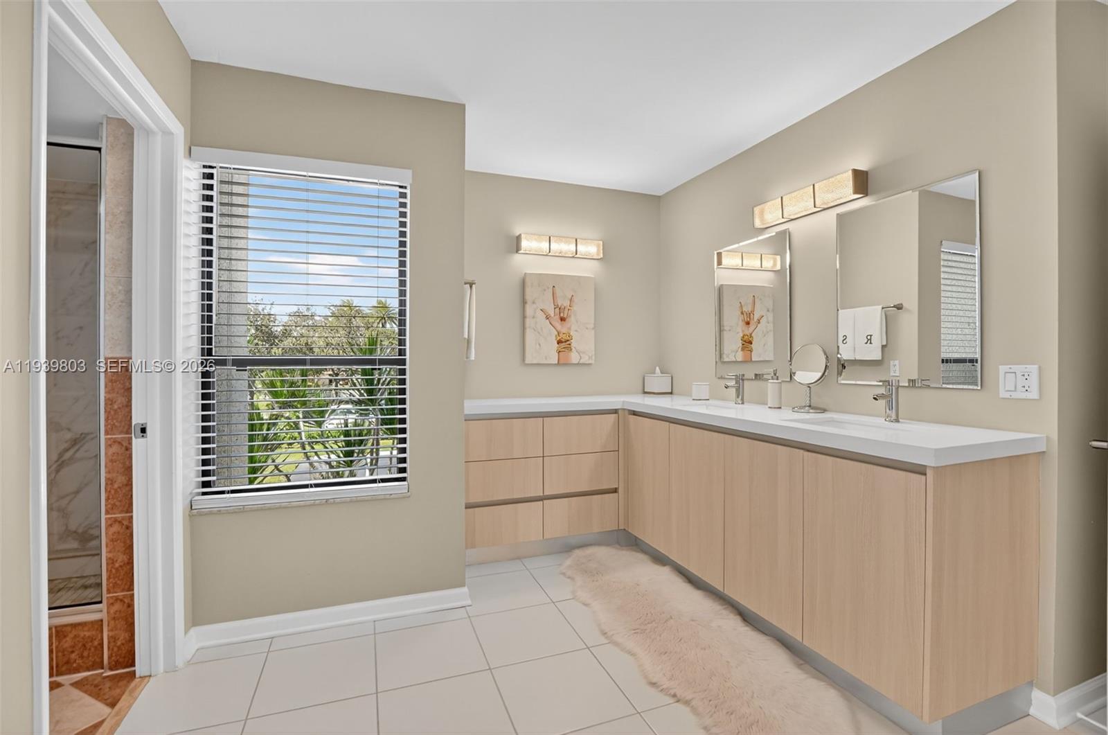 5901 Camino Del Sol, Unit 207 Boca Raton, FL 33433 - Photo 24 of 53 a large white bathroom with a double vanity sink a mirror a window and a bathtub