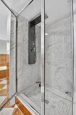 a bathroom with a shower and a glass door