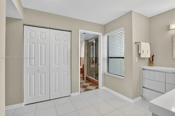 a view of an empty room with window and cabinet