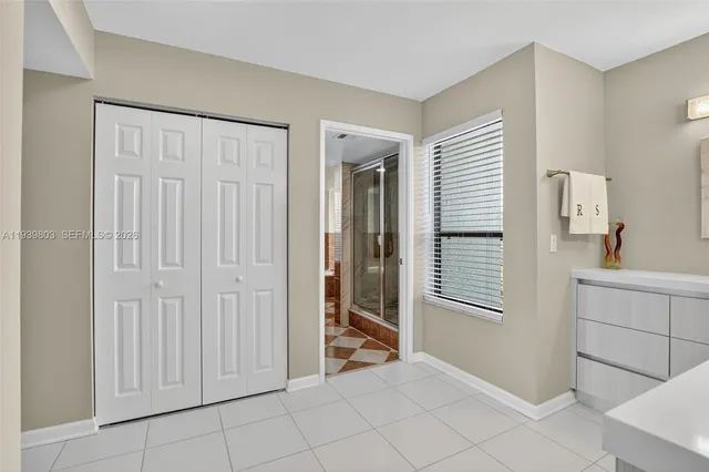 a view of an empty room with window and cabinet