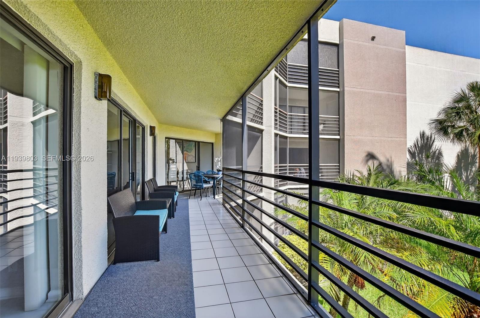 5901 Camino Del Sol, Unit 207 Boca Raton, FL 33433 - Photo 33 of 53 a view of a balcony with chairs and wooden floor