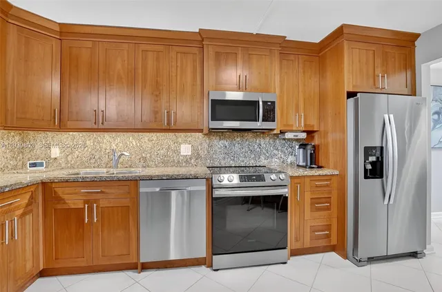 a kitchen with stainless steel appliances granite countertop a stove microwave and refrigerator