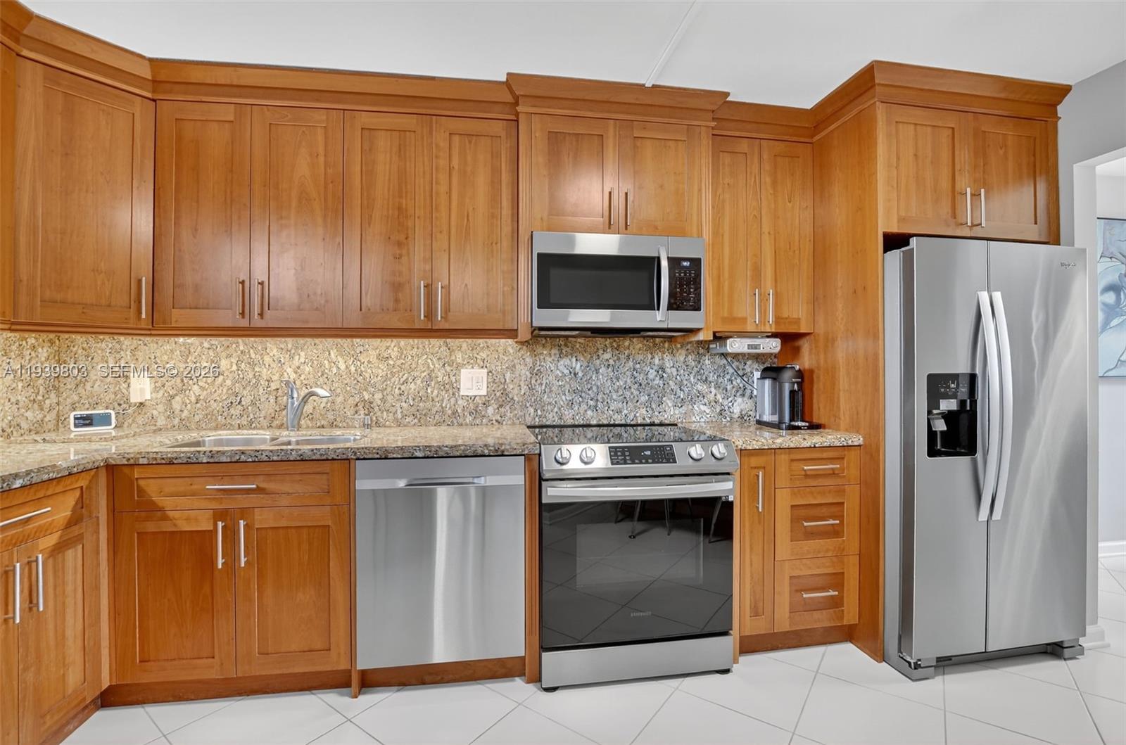 5901 Camino Del Sol, Unit 207 Boca Raton, FL 33433 - Photo 7 of 53 a kitchen with stainless steel appliances granite countertop a stove microwave and refrigerator