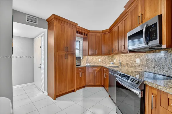 a kitchen with stainless steel appliances granite countertop a refrigerator and a sink