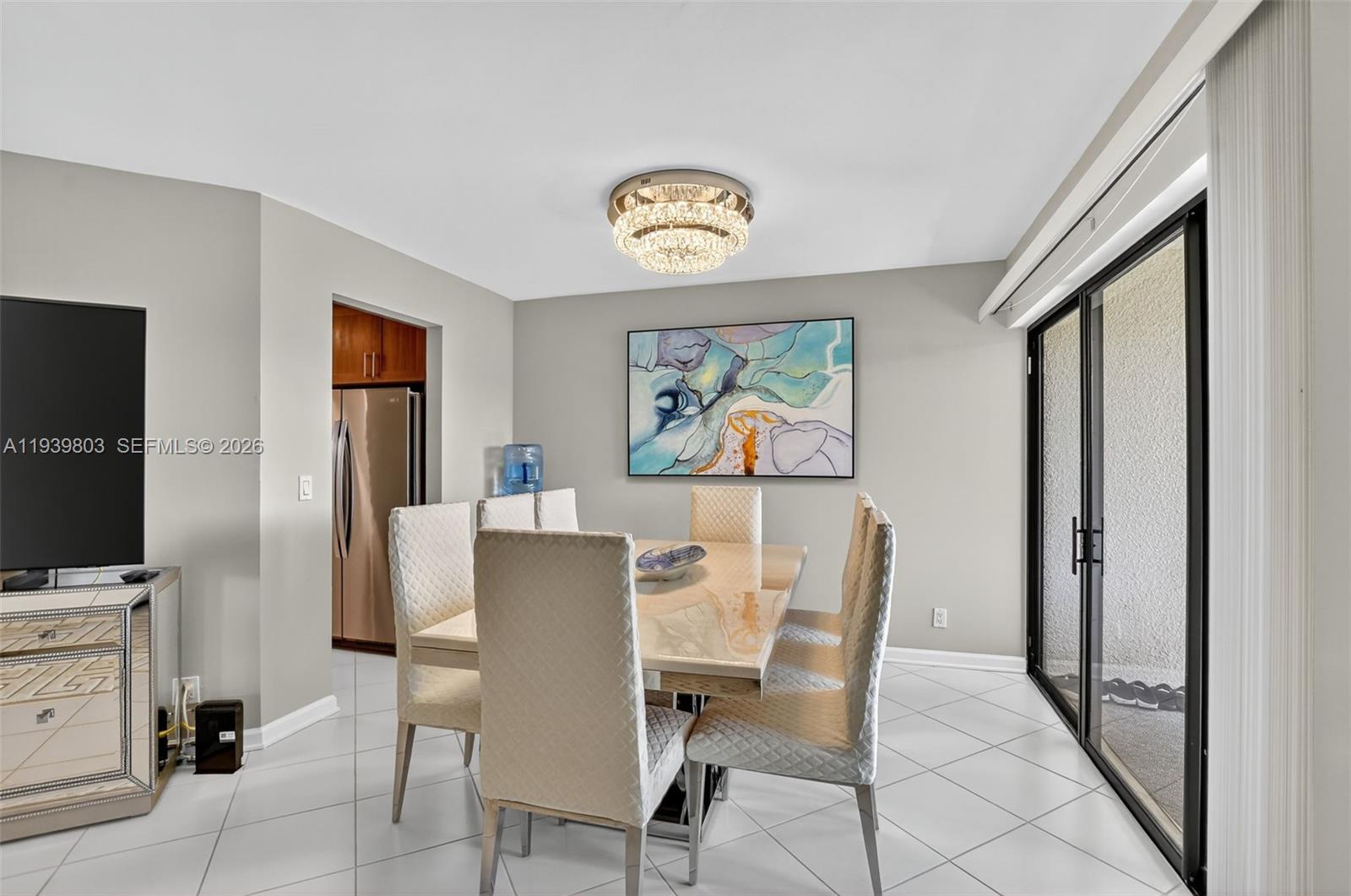 5901 Camino Del Sol, Unit 207 Boca Raton, FL 33433 - Photo 9 of 53 a view of a dining room with furniture a chandelier and wooden floor