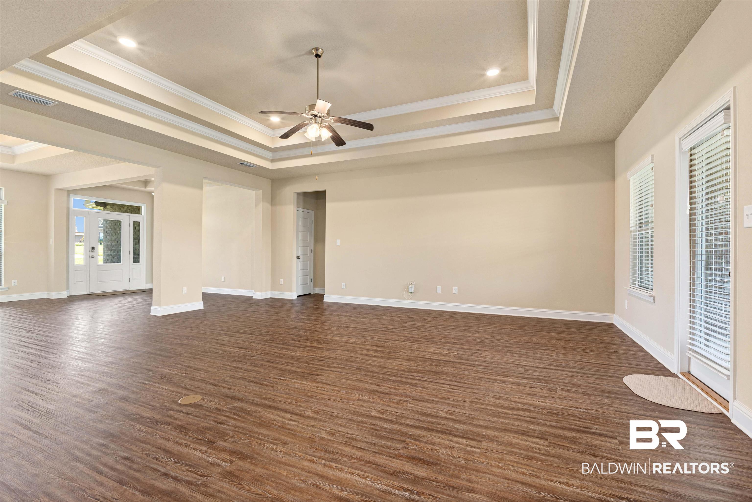 1864 Gwin Court Mobile, AL 36695 - Photo 7 of 37 Interior space featuring ceiling fan, a raised ceiling, dark hardwood / wood-style floors, and ornamental molding