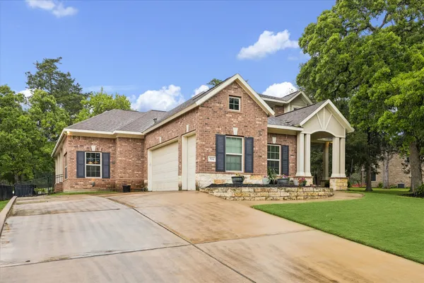 a front view of a house with yard and green space