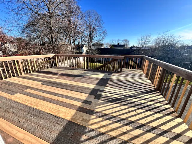 a view of a balcony with wooden floor and fence