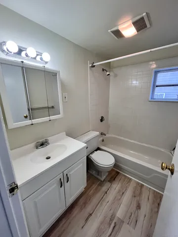 a bathroom with a toilet sink a mirror and vanity