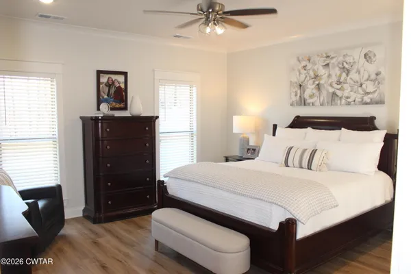 a bedroom with a bed and wooden floor