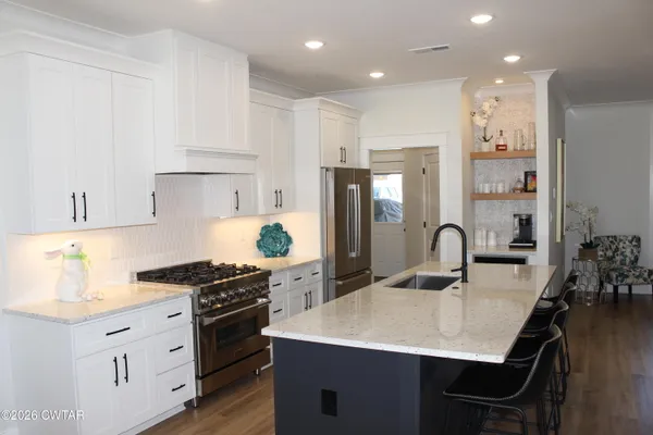 a kitchen with kitchen island a sink stove and refrigerator