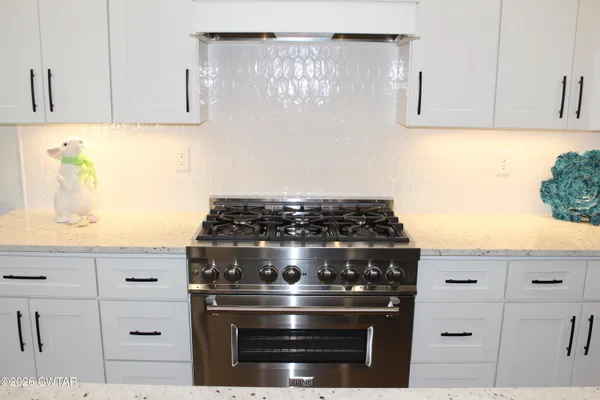 a stove top oven sitting inside of a kitchen