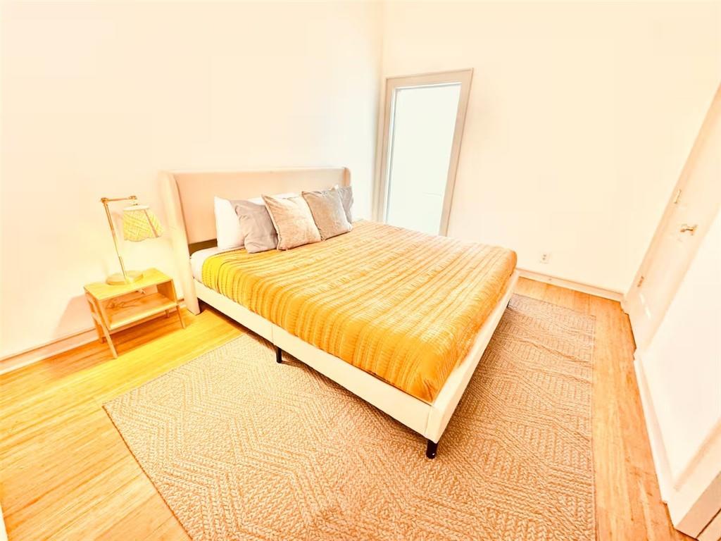 175 River Ct Parkway Atlanta, GA 30328 - Photo 34 of 50 a bed sitting in a bedroom next to a blue wall with a large window