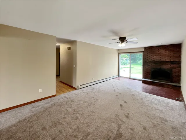 an empty room with windows and fireplace