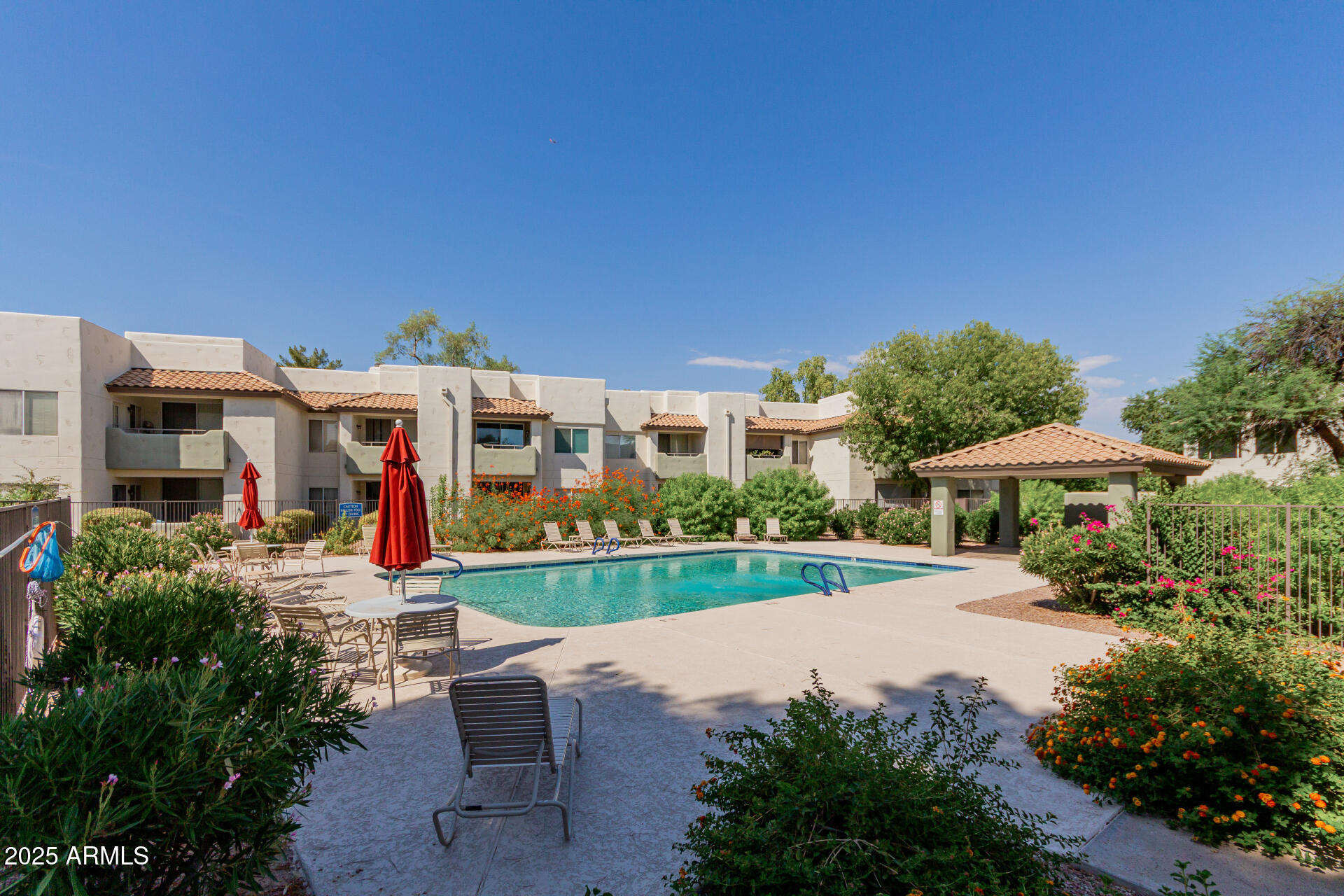 1825 West Ray Road, Unit 2070 Chandler, AZ 85224 - Photo 30 of 51 a view of a house with table and chairs under an umbrella