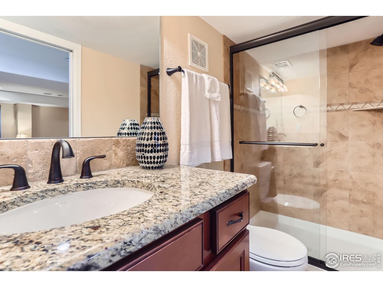 1069 Monarch Way Superior, CO 80027 - Photo 30 of 40 a bathroom with a granite countertop sink a mirror and shower