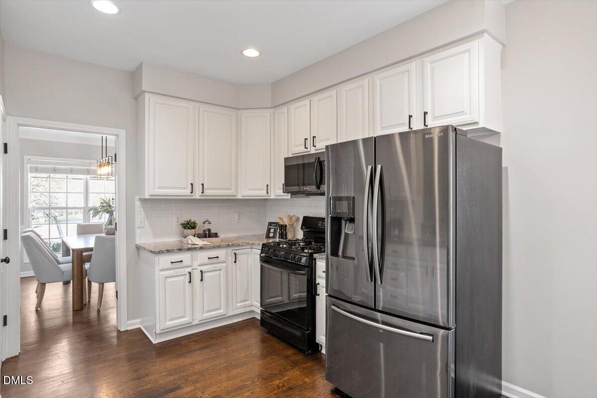 327 Whitney Lane Durham, NC 27713 - Photo 7 of 33 a kitchen with stainless steel appliances a refrigerator and wooden floor