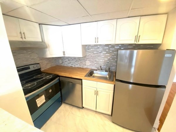466 Commonwealth Avenue, Unit 302 Boston, MA 02215 - Photo 4 of 12 a kitchen with a sink a stove and a refrigerator