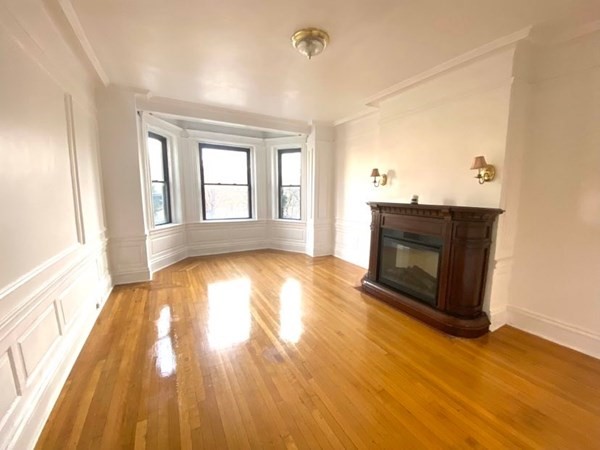 466 Commonwealth Avenue, Unit 302 Boston, MA 02215 - Photo 5 of 12 wooden floor fireplace and windows in an empty room