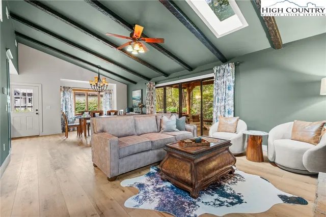 a living room with furniture a large window and a rug