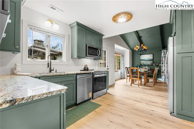 a large kitchen with granite countertop a stove and a sink