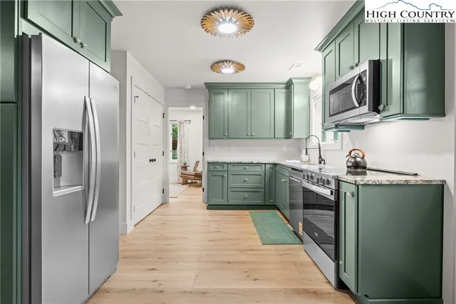 a large kitchen with stainless steel appliances granite countertop a refrigerator and a sink