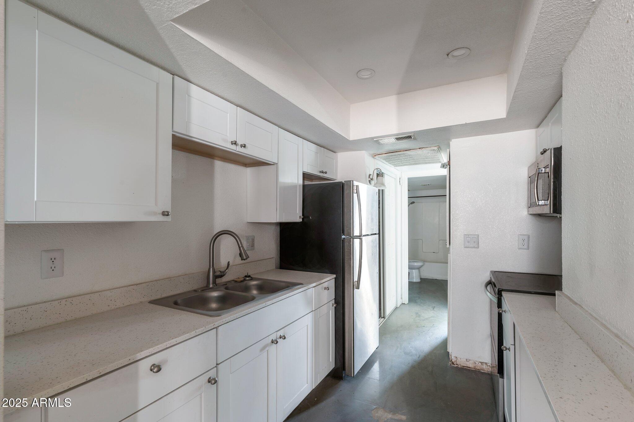 a kitchen with a refrigerator and a sink