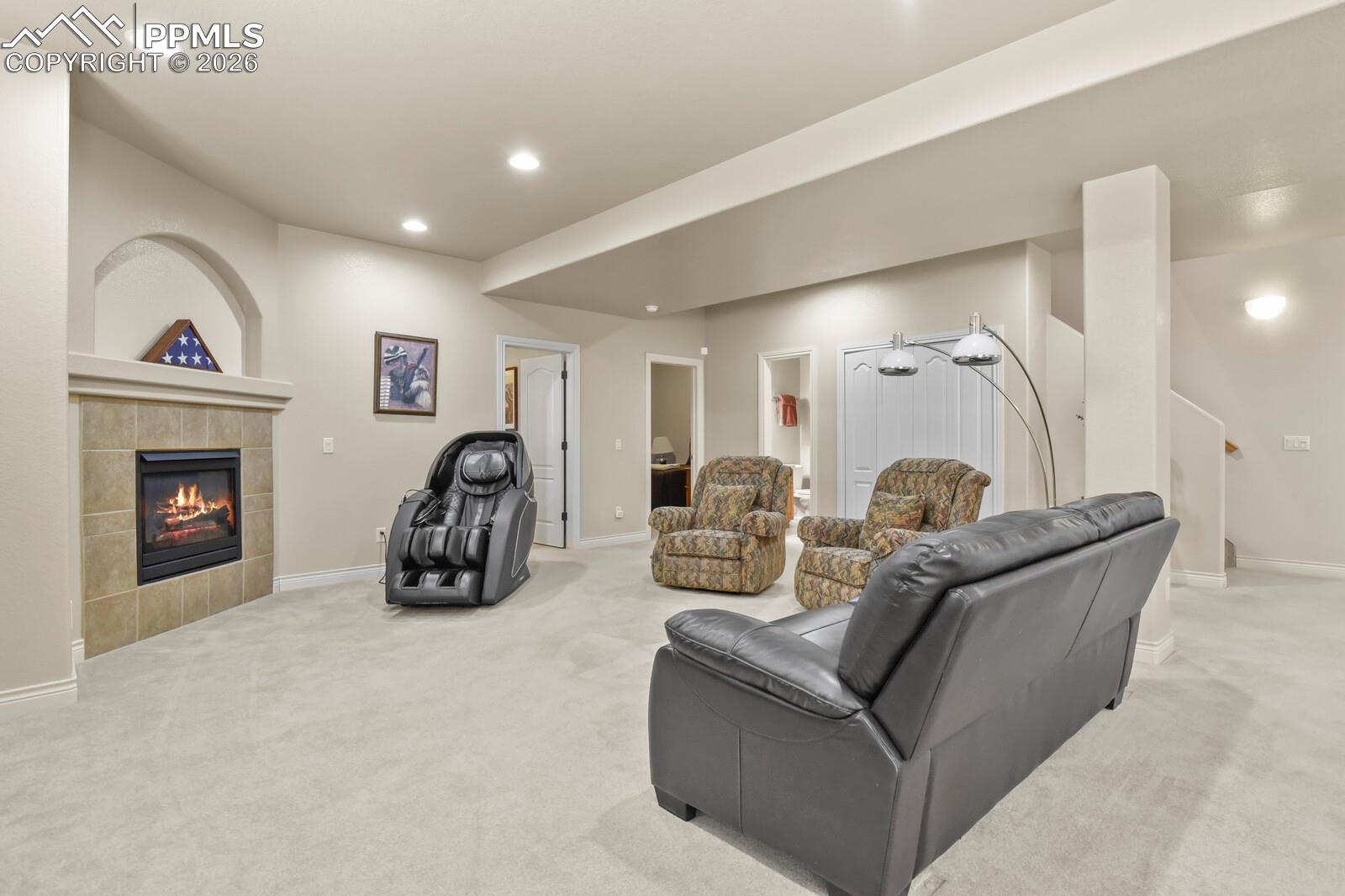 617 Concerto Drive Colorado Springs, CO 80906 - Photo 29 of 46 Living area featuring neutral-toned carpeting, a fireplace with a tiled surround, recessed lighting, and an arched niche above the fireplace