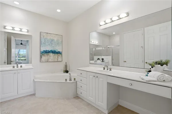 a bathroom with a sink a mirror and a potted plant